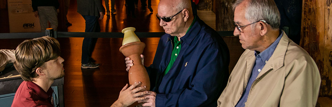 Blind man feeling pottery